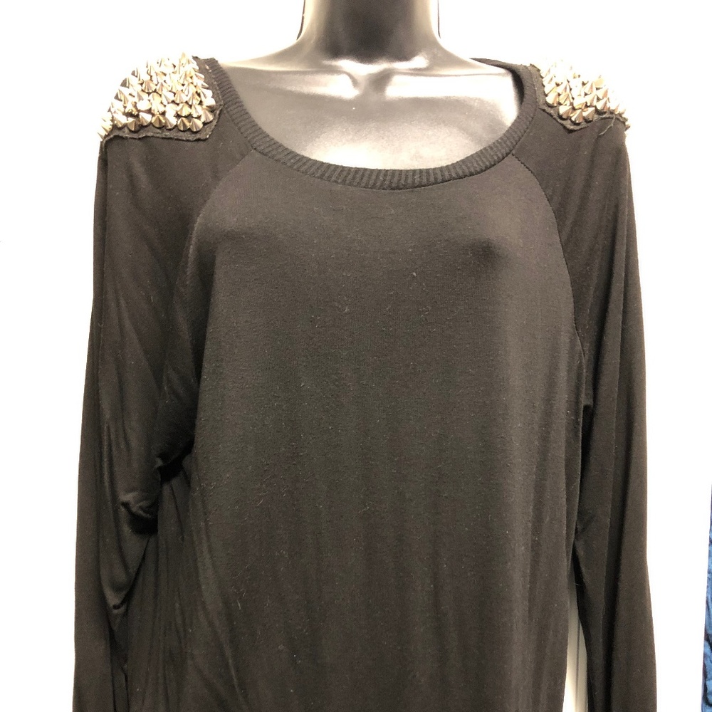 Black sweater with spiked studs on each shoulder.